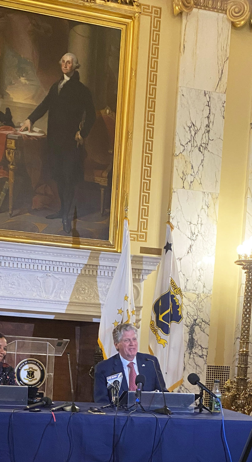 Gov. Dan McKee at a news conference at the State House, underneath the portrait of George Washington.